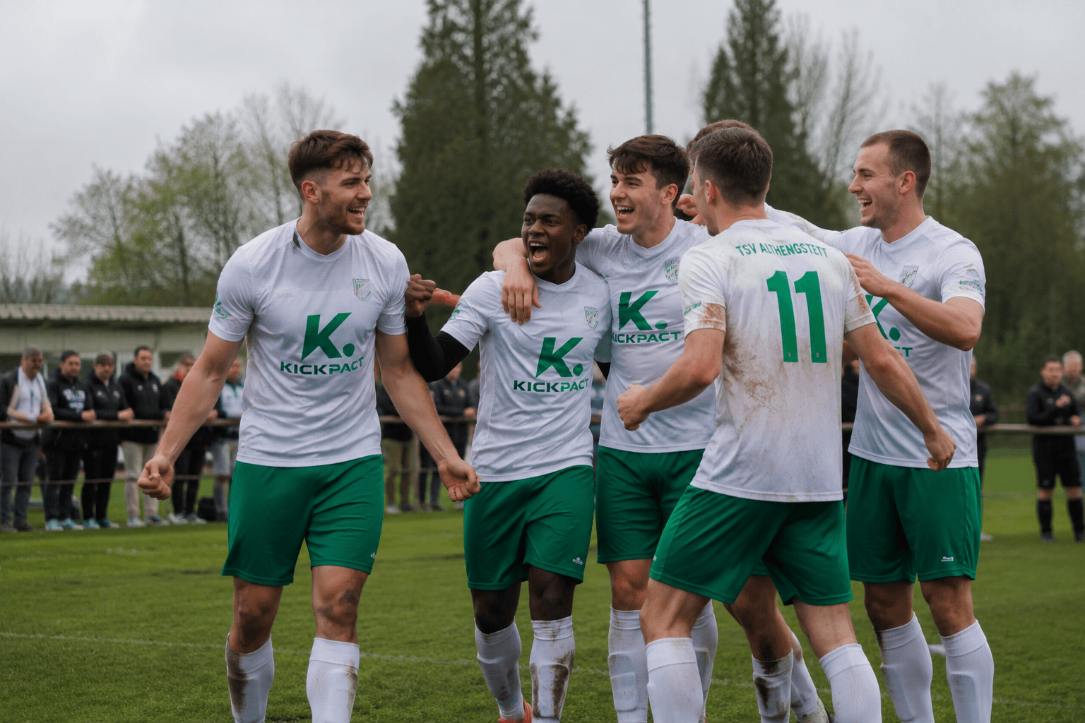 Mannschaft in weißen KickPact-Trikots jubelt nach Tor
